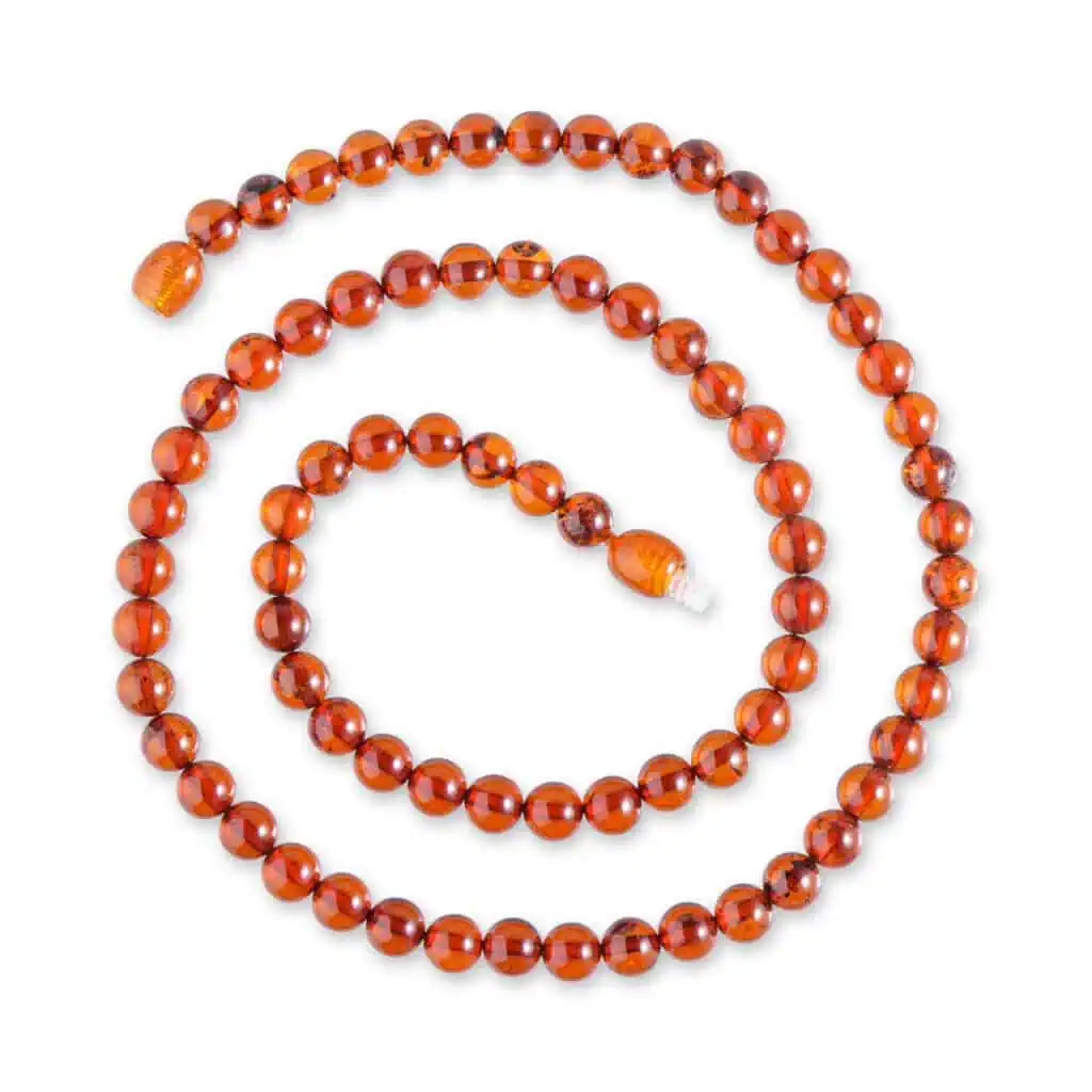 Elegant Baltic amber necklace with cognac beads accented by a sophisticated black satin blouse.