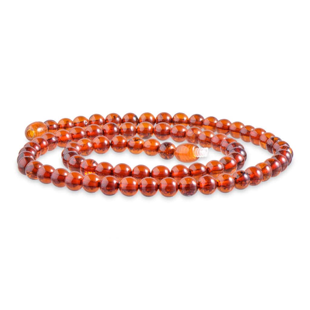 Polished amber beads in rich cognac tones, elegantly arranged for jewelry and decorative accents.