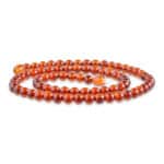 Polished amber beads in rich cognac tones, elegantly arranged for jewelry and decorative accents.