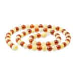 Elegant Baltic amber and ivory beaded necklace with polished, contrasting, and beautifully arranged beads.