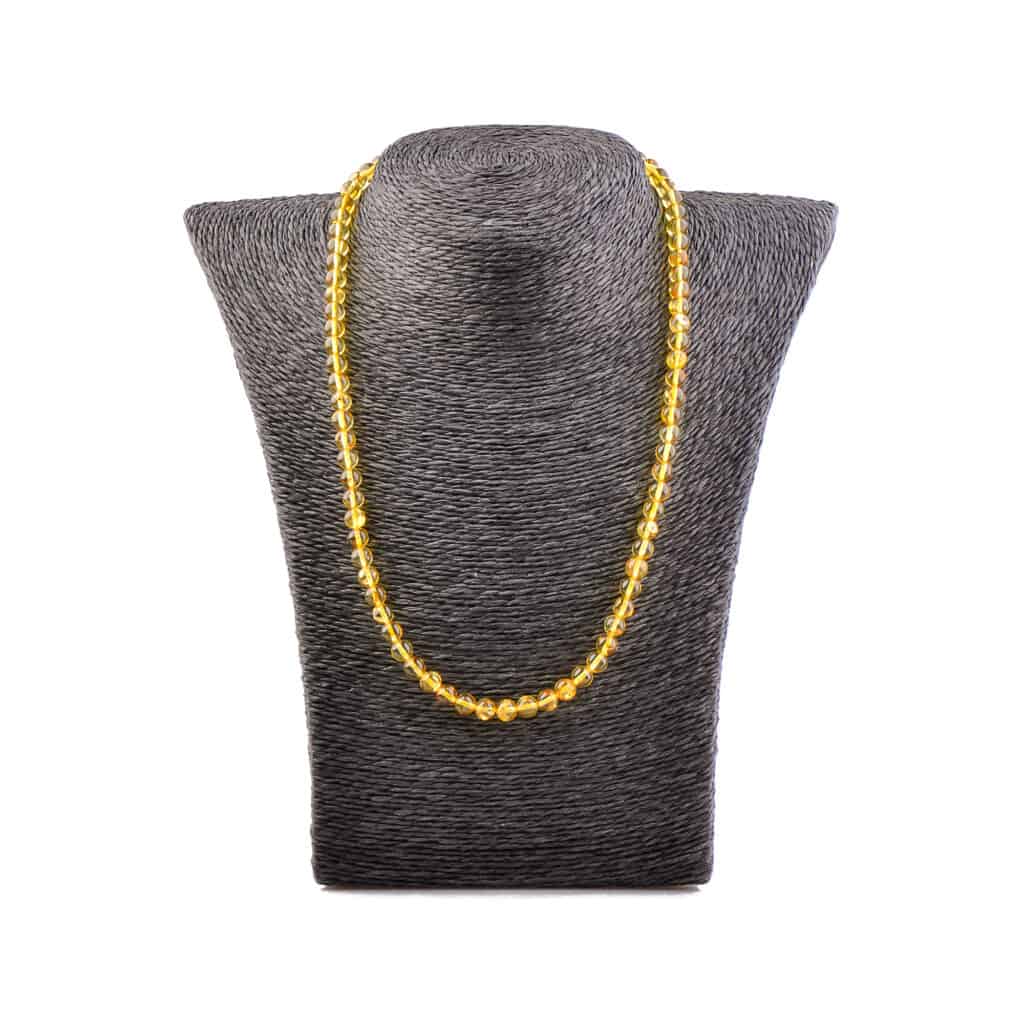 Beautiful gold-tone beaded necklace displayed on textured bust, perfect for elegant or casual outfits.
