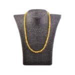 Beautiful gold-tone beaded necklace displayed on textured bust, perfect for elegant or casual outfits.