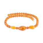 Amber bracelet with honey-colored beads and leaf-shaped accent, elegant and natural jewelry accessory.