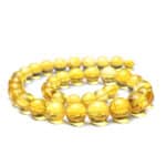 Vivid yellow amber bead necklace with polished, translucent, warm-toned round beads for elegant style.