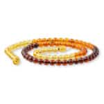 Handcrafted amber necklace with warm, gradient beads and elegant gold clasp for timeless style.