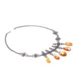 Elegant silver necklace with vibrant orange gemstones and vintage floral motifs, perfect for special occasions.
