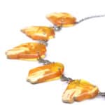 Vibrant Baltic amber necklace with organic petal shapes and delicate silver chain.