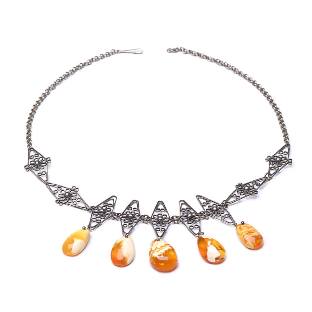 Elegant silver necklace with marbled orange teardrop gemstones and geometric metal accents.