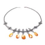 Elegant silver necklace with marbled orange teardrop gemstones and geometric metal accents.