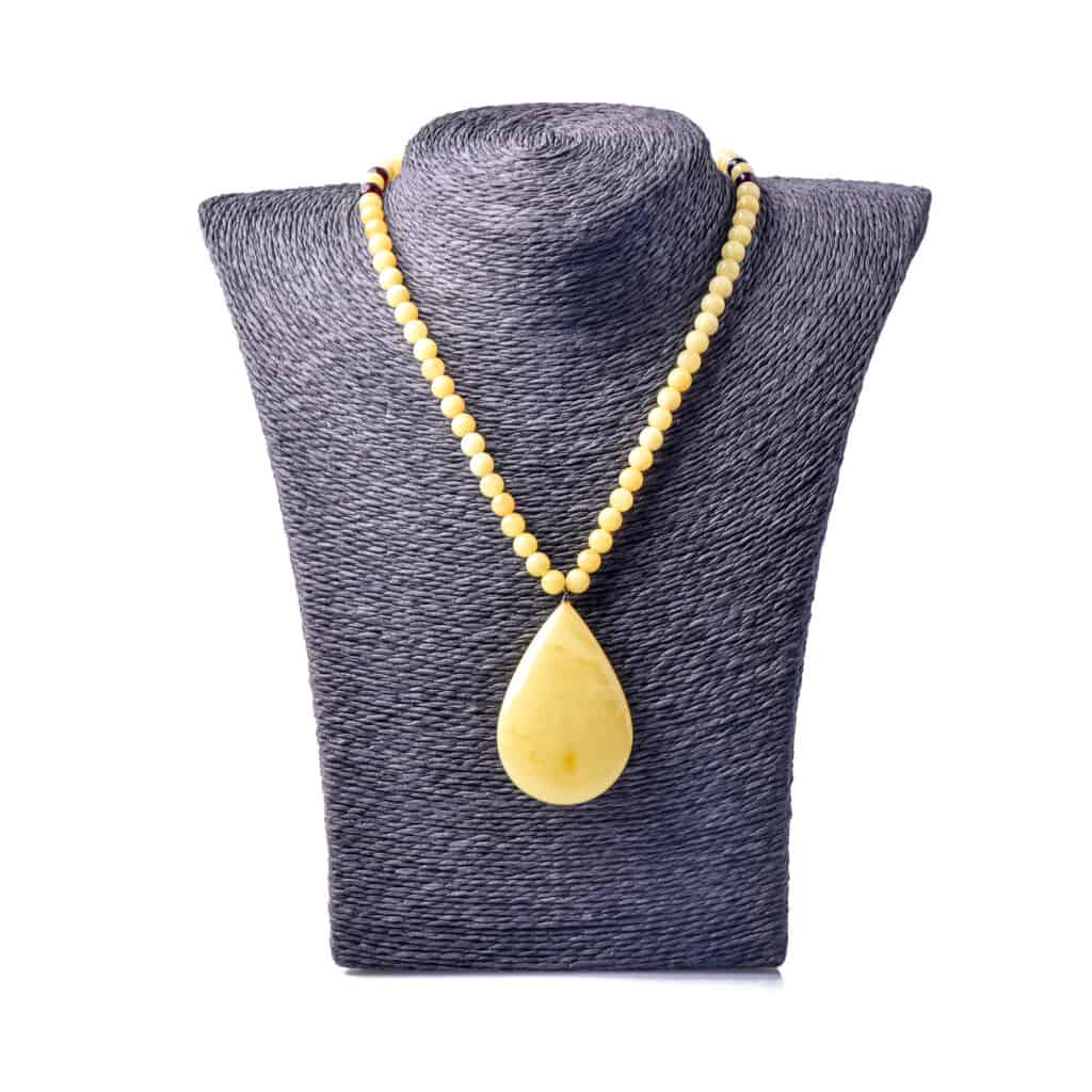 Elegant Baltic amber necklace with teardrop pendant on display, blending simplicity and sophisticated craftsmanship.
