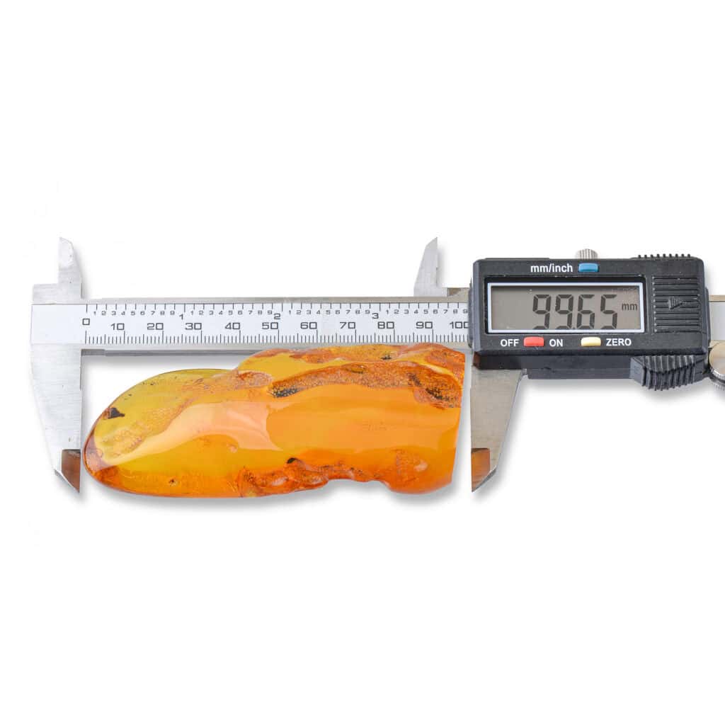 Large Baltic amber specimen measuring 99.65mm with natural inclusions and vibrant golden color.
