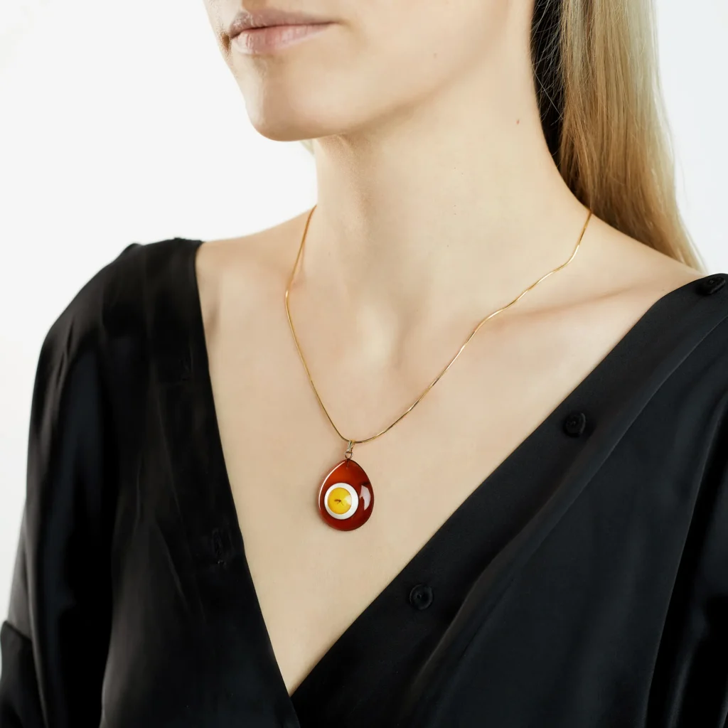Baltic amber necklace with playful fried egg pendant and elegant gold chain, stylish and unique.