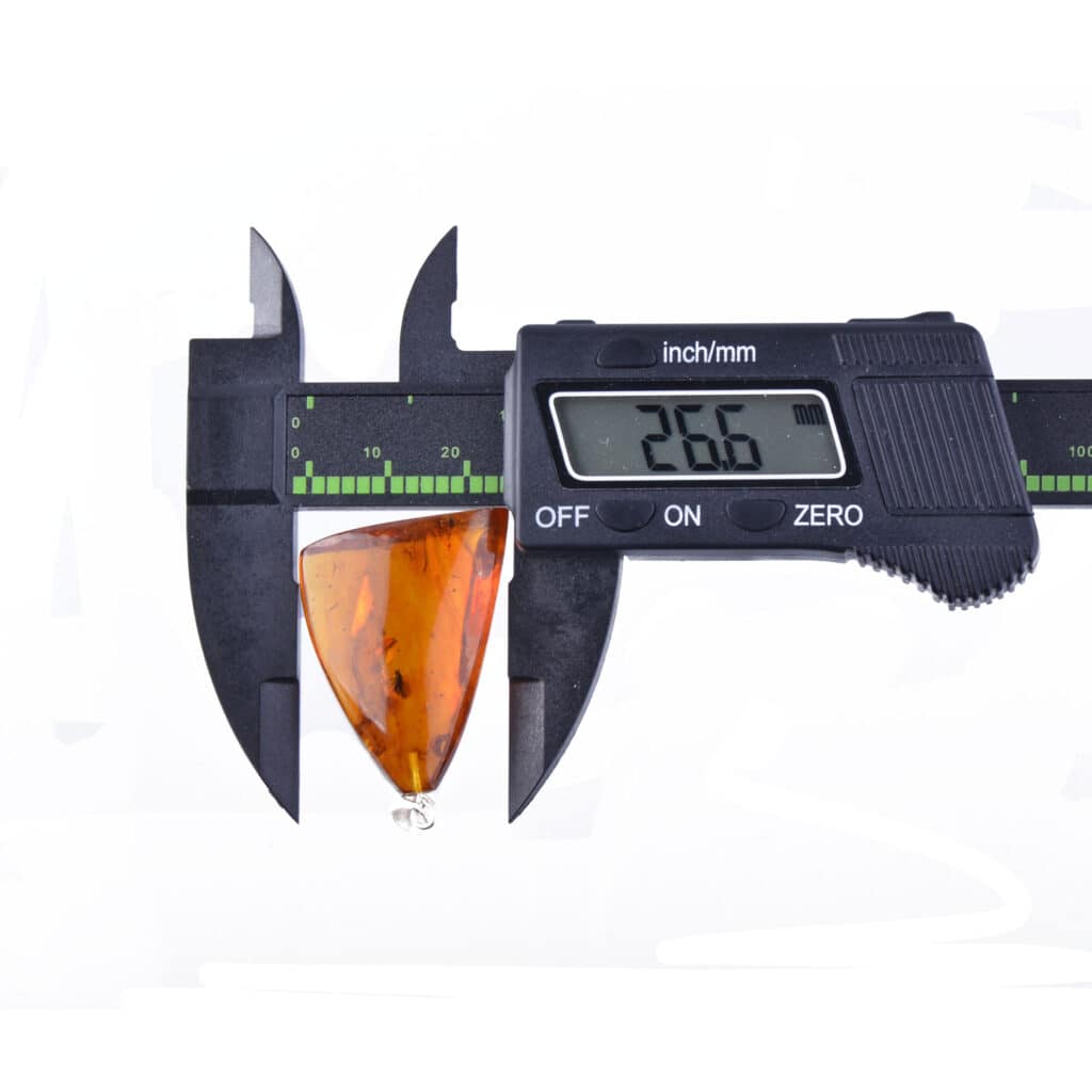 Digital caliper measuring an orange triangular object, highlighting precision in manufacturing and craftsmanship.