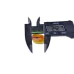 Digital caliper measuring a polished amber piece with a 2.42 mm reading.