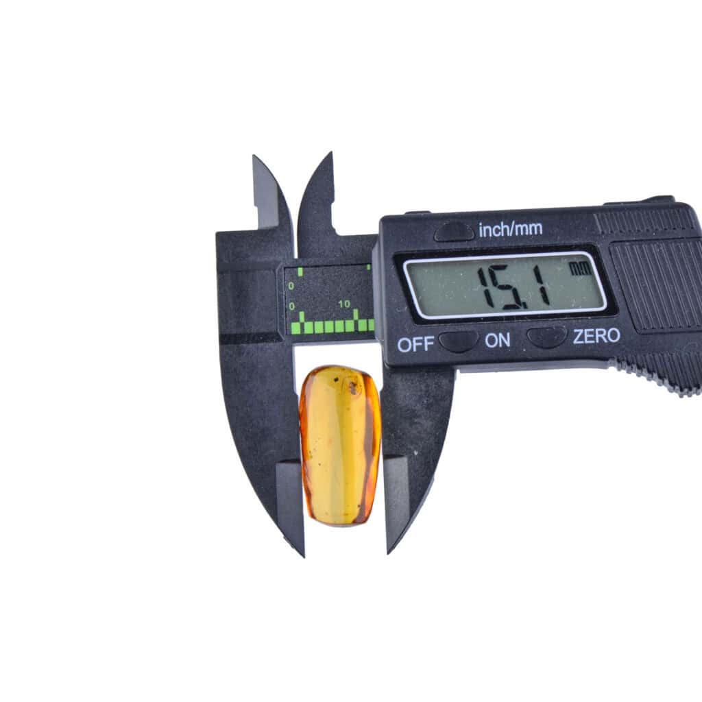 Digital caliper measuring a small, amber gemstone with a 15.1 mm reading.
