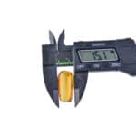 Digital caliper measuring a small, amber gemstone with a 15.1 mm reading.
