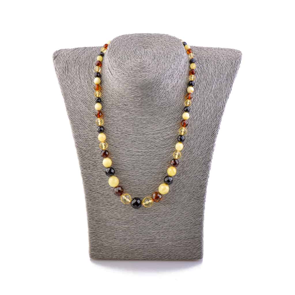 Natural Baltic amber necklace in warm cognac tones displayed on a gray bust.
