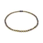 Elegant Baltic amber necklace with dark accents and gold highlights, timeless and versatile jewelry piece.