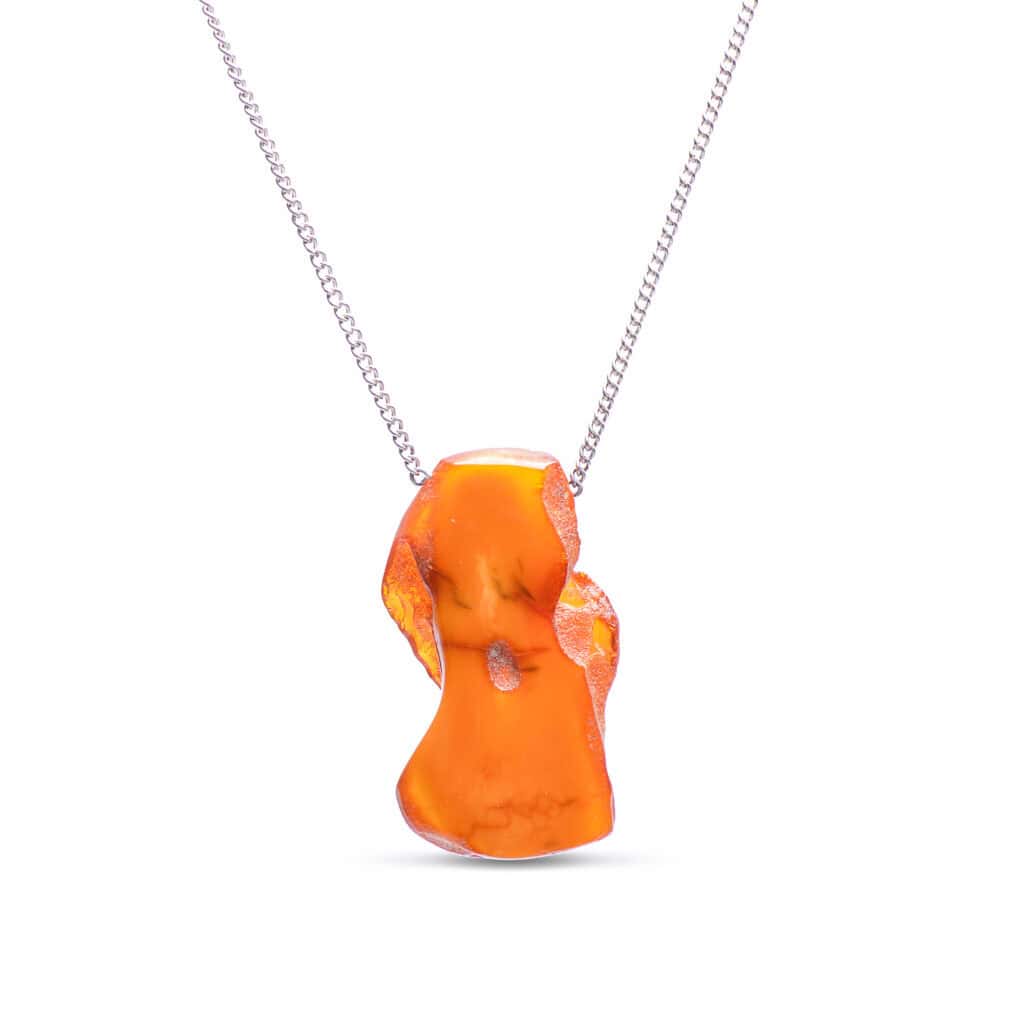Vibrant organic amber pendant on silver chain, stylish natural jewelry for casual or formal wear.