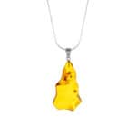 Golden Baltic amber pendant with natural inclusions on a silver chain for elegant everyday wear.