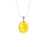 Golden amber pendant with natural inclusions on delicate silver chain, timeless and elegant jewelry piece.