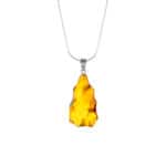 Vivid amber pendant necklace with organic shape and silver chain, elegant and handcrafted jewelry.
