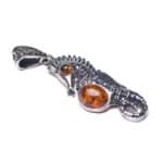 Handmade sterling silver seahorse pendant with warm Baltic amber accents, ocean-inspired jewelry.