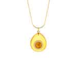 Golden teardrop amber pendant necklace on delicate gold chain, elegant and artisanal jewelry accessory.
