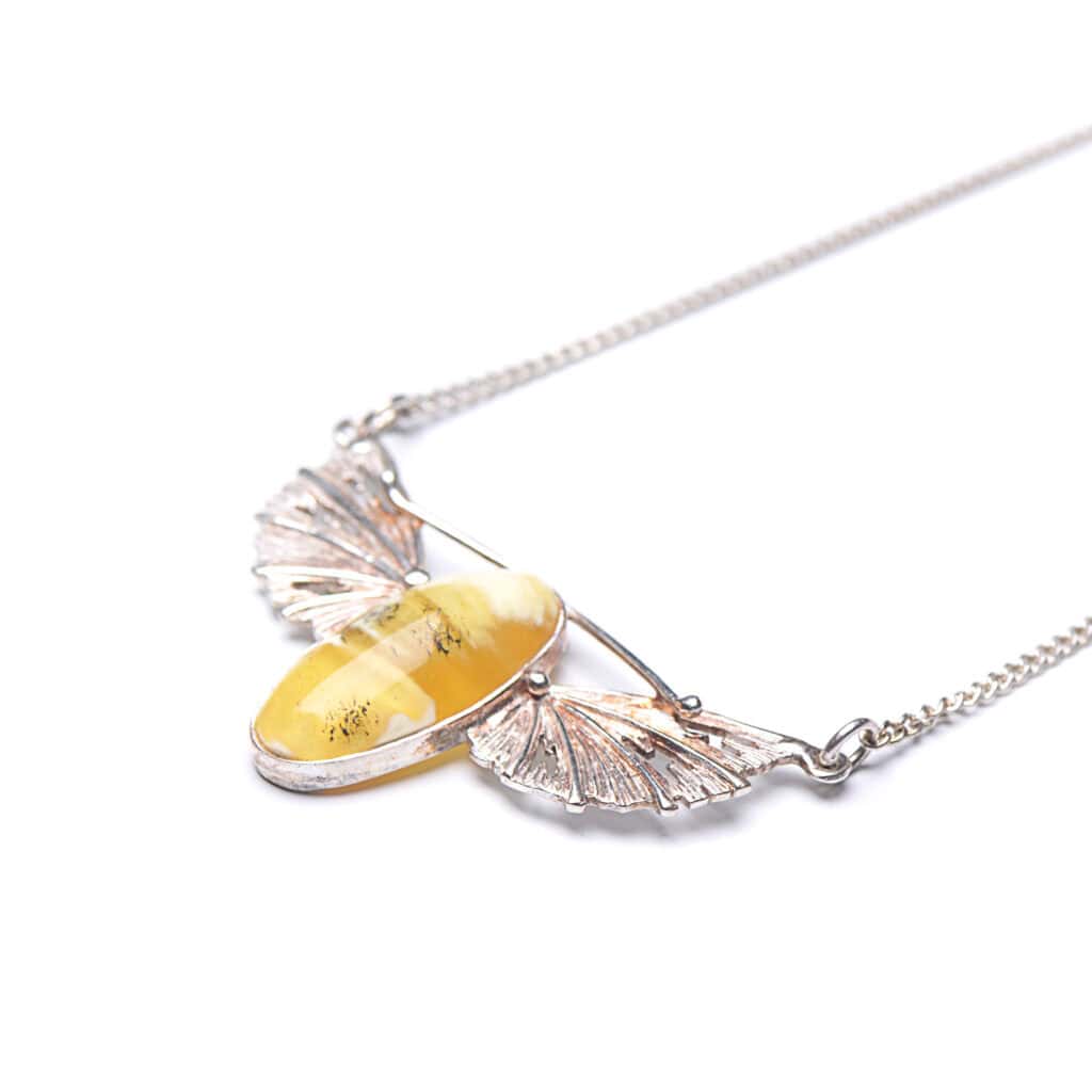 Elegant Baltic amber necklace with silver wings and vibrant yellow gemstone accent.