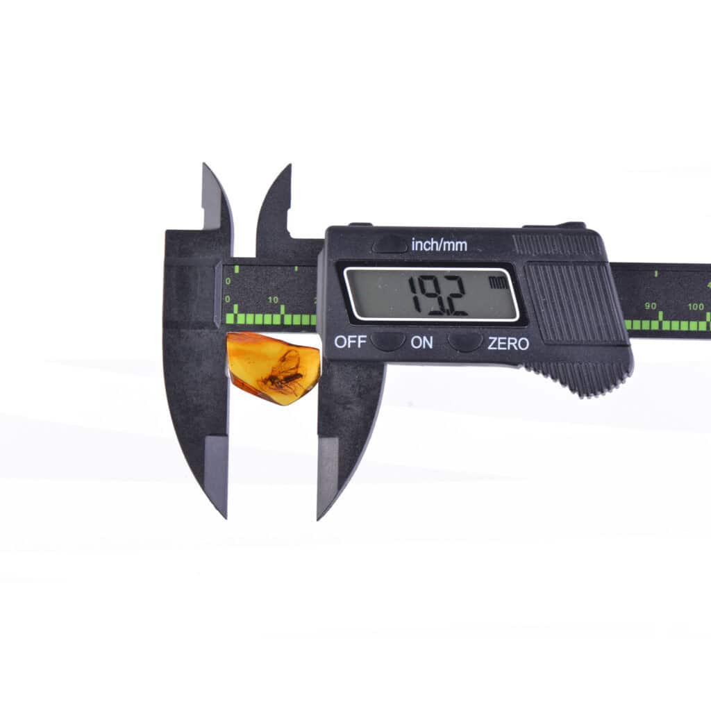 Digital caliper measuring yellow object at 19.2 inches, showcasing precision and measurement tools.