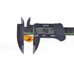 Digital caliper measuring yellow object at 19.2 inches, showcasing precision and measurement tools.