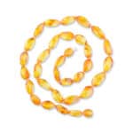 Spiral arrangement of vibrant yellow-orange translucent beads forming a stunning, handcrafted jewelry piece.