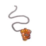 Vibrant orange amber necklace with floral pendant on sleek, modern metal chain for stylish elegance.