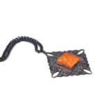 Vintage Baltic amber pendant necklace with intricate dark metal frame and chain.