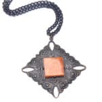 Vintage amber pendant necklace with intricate metalwork and a brass chain, elegant and timeless.
