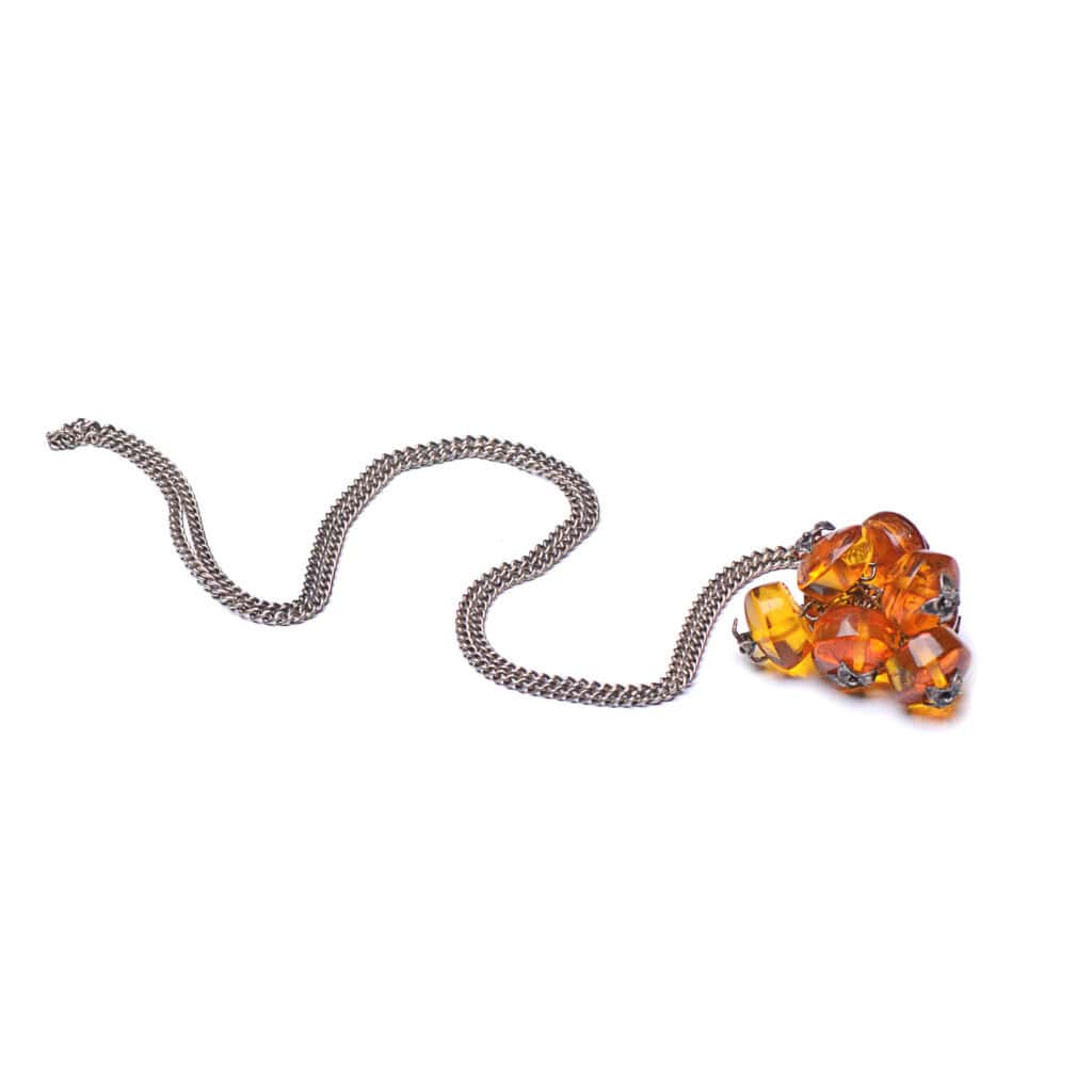 Vibrant amber pendant necklace with sleek metallic chain and organic, faceted gemstone design.