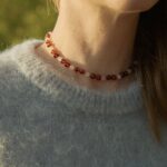 natural amber with quartz on a woman's neck surrounded by nature