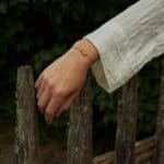natural amber with red string on woman hand