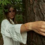 natural amber with red string on woman hand