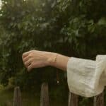 natural amber bracelet with three center beads, red string. On a woman's hand against a natural background