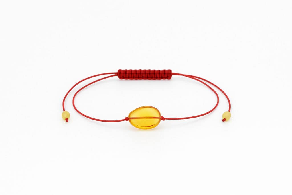 honey-colored amber with red string in the center of the bracelet