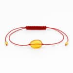 honey-colored amber with red string in the center of the bracelet