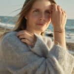 woman by the sea with a natural amber barrel-shaped bracelet